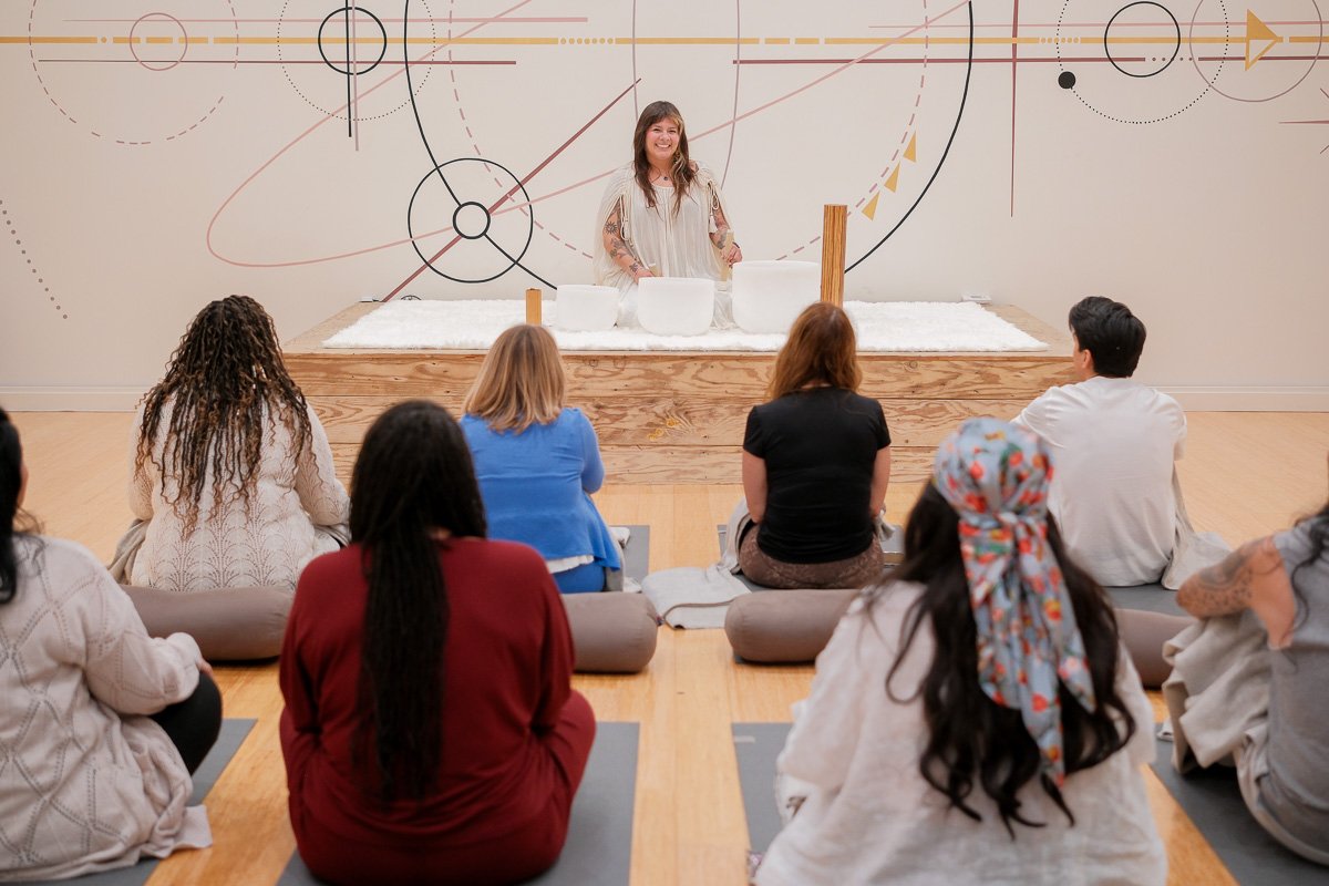 Isabella Rivera leading a sound bath with crystal singing bowls for a seated group